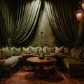 Cozy lounge with draped curtains, wooden tables, and plush seating.