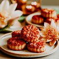 Mooncakes on a plate with flowers and candles in the background